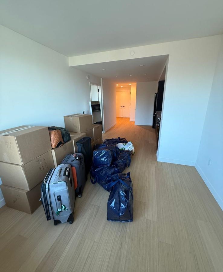 Leere Wohnung mit Umzugskartons und Koffern nach dem Einzug durch EMAY Transport